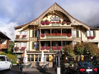 Die imposante, mit herrlichen Holzschnitzereien verzierte Fassade des Hotels "Post Hardermannli" in Interlaken