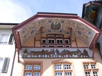 Fassade der "Alten Schaal" in Aarau mit prächtig bemaltem Bogengiebel (Ründe) und darunterliegendem Gemälde